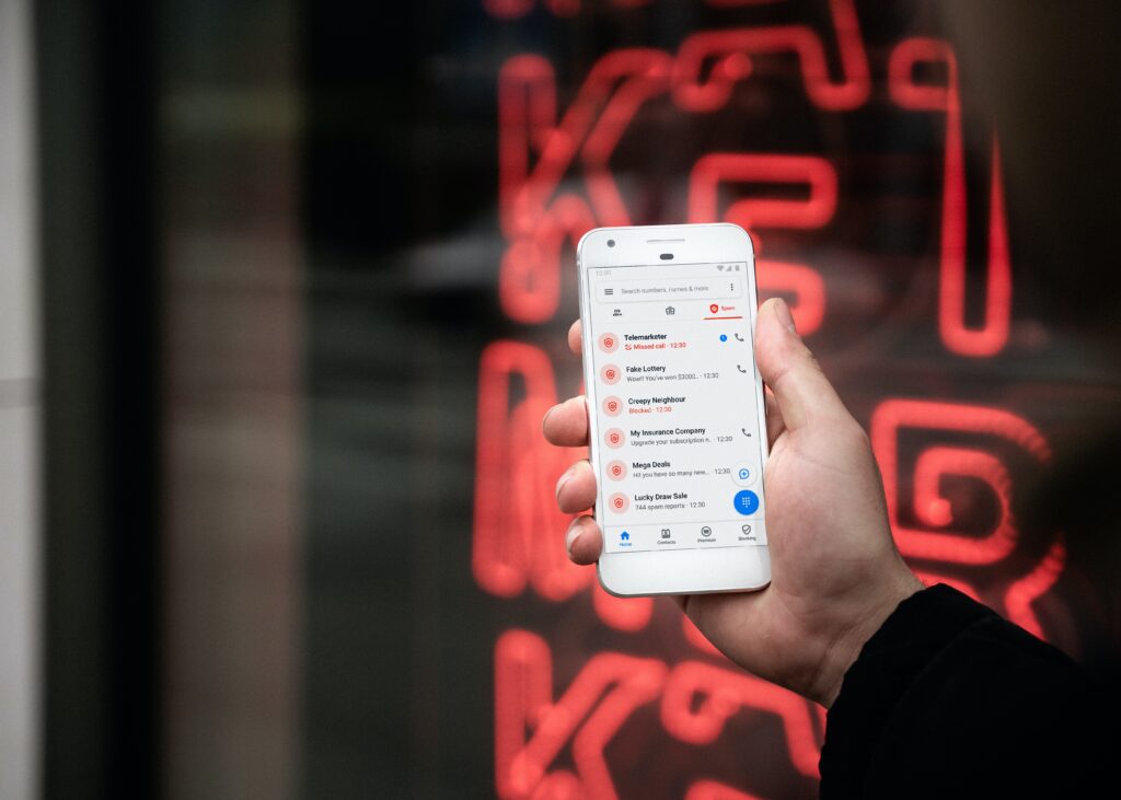 Picture of phone with scam calls in hand