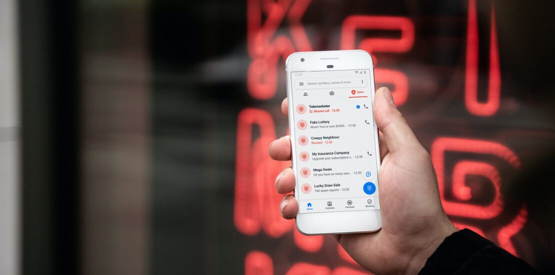 Picture of phone with scam calls in hand